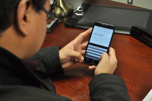 Cherokee Nation Language Program Manager Roy Boney uses Cherokee syllabary on a smartphone. Cherokee Nation and Rogers State University Public TV are teaming up to launch the first televised Cherokee language learning course beginning Jan. 13.