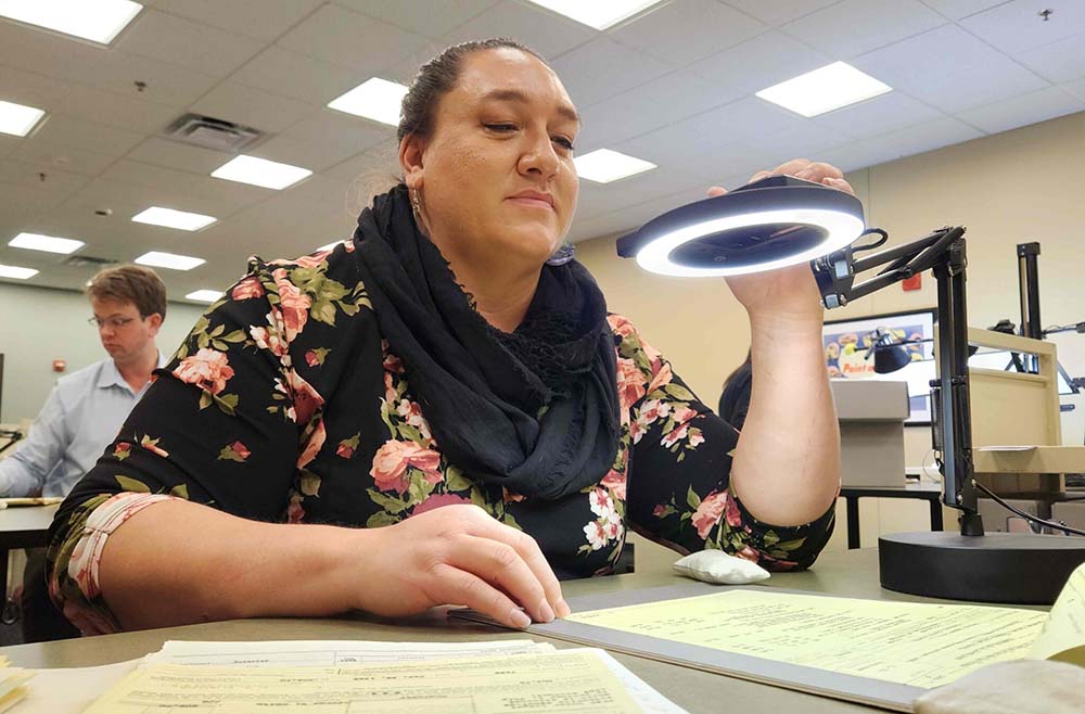 Prairie Rose Seminole works to digitize records of the Bismarck Indian School on Jan. 3, 2025, at the National Archives in Kansas City, Mo. (Photo provided by Dennis J. Neumann)