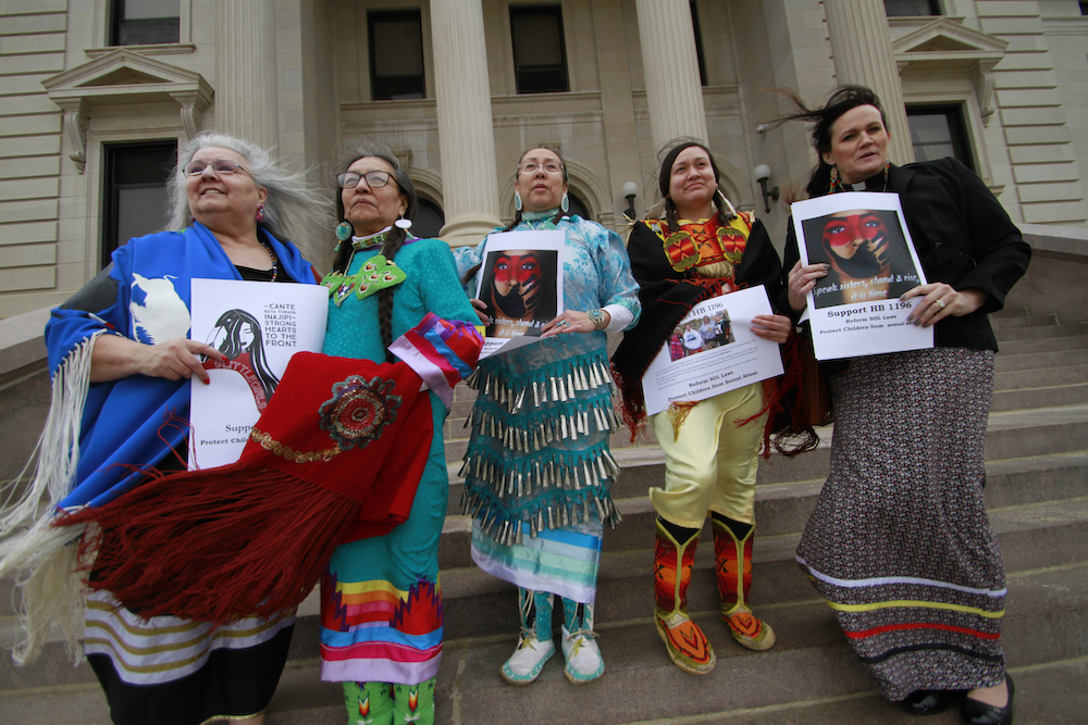 From Left, Geraldine Dubourt, Francis Hart, Marie Ogitchida, Mikayla Maxwell and Michelle Dauphinais Echols stand on the steps of the South Dakota Capitol in Pierre, S.D. on Monday, Feb. 24, 2020. Lawmakers killed a bill that would have given survivors of childhood sexual abuse a two-year window to sue organizations in which abuse occurred. (AP Photo/Stephen Groves)