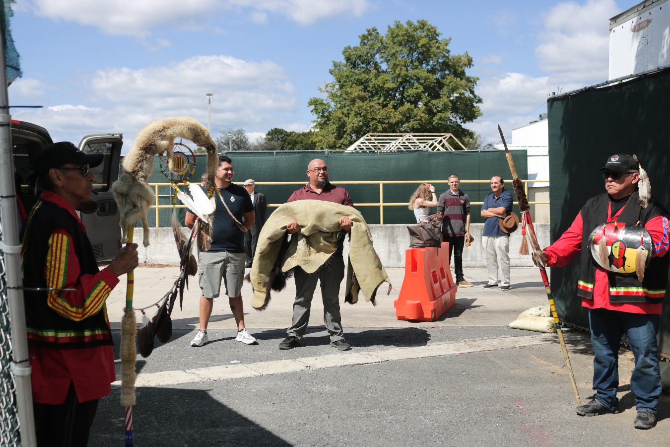 KJ Greywater of the Spirit Lake Nation, a veteran and the Tribal Historic Preservation Officer, awaits Amos and Edward’s transfer to the tribal van with a buffalo hide. Greywater led the way for the return of the children. (Photo: Jenna Kunze).