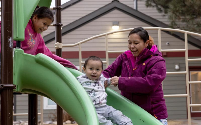 Katarina Stewart and her children Josette and Donovan play in the park at her apartment complex in Billings on Jan. 3, 2024. Credit: Tailyr Irvine / MTFP