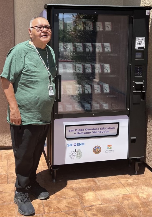 Pala Band Chairman Robert Smith, who lost two young cousins to opioid overdoses, stands alongside the new Narcan vending machine at the Tribe’s fire department. (Photo: Courtesy of Pala Band of Mission Indians)