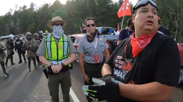 Nick Tilsen (far right) was arrested at the Mount Rushmore protests of President Donald Trump and charged with multiple offenses. He was the only person arrested to spend the entire weekend in jail. (Photograph from NDN Collective video.)
