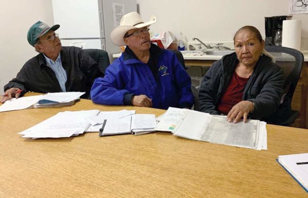 Navajo Times | Cindy Yurth - Eddie Draper, center, and Bertha Tom, of Baahaali, show their files of documentation for their range unit while land board member Robert Delgarito looks on. Draper and Tom said they’ve always complied with grazing law and don’t know why their range unit was transferred to another person.