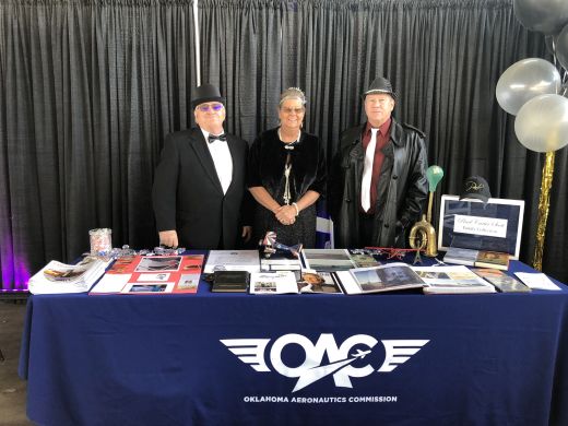 Pearl Carter Scott’s grandchildren stand behind memorabilia from their famous Chickasaw aviator grandmother at a reception held in her honor by the Ninety-Nines women pilots’ organization. Left to right are Bill Thompson, Georgia Smith and Craig Thompson. Craig Thompson is a retired commercial airline pilot who currently serves as Ada, Oklahoma's airport manager.